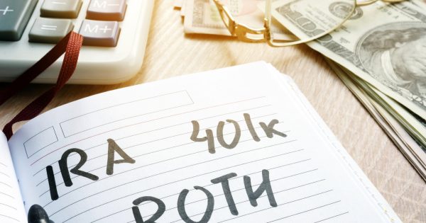 Words IRA 401k ROTH handwritten in a note. Retirement plans.